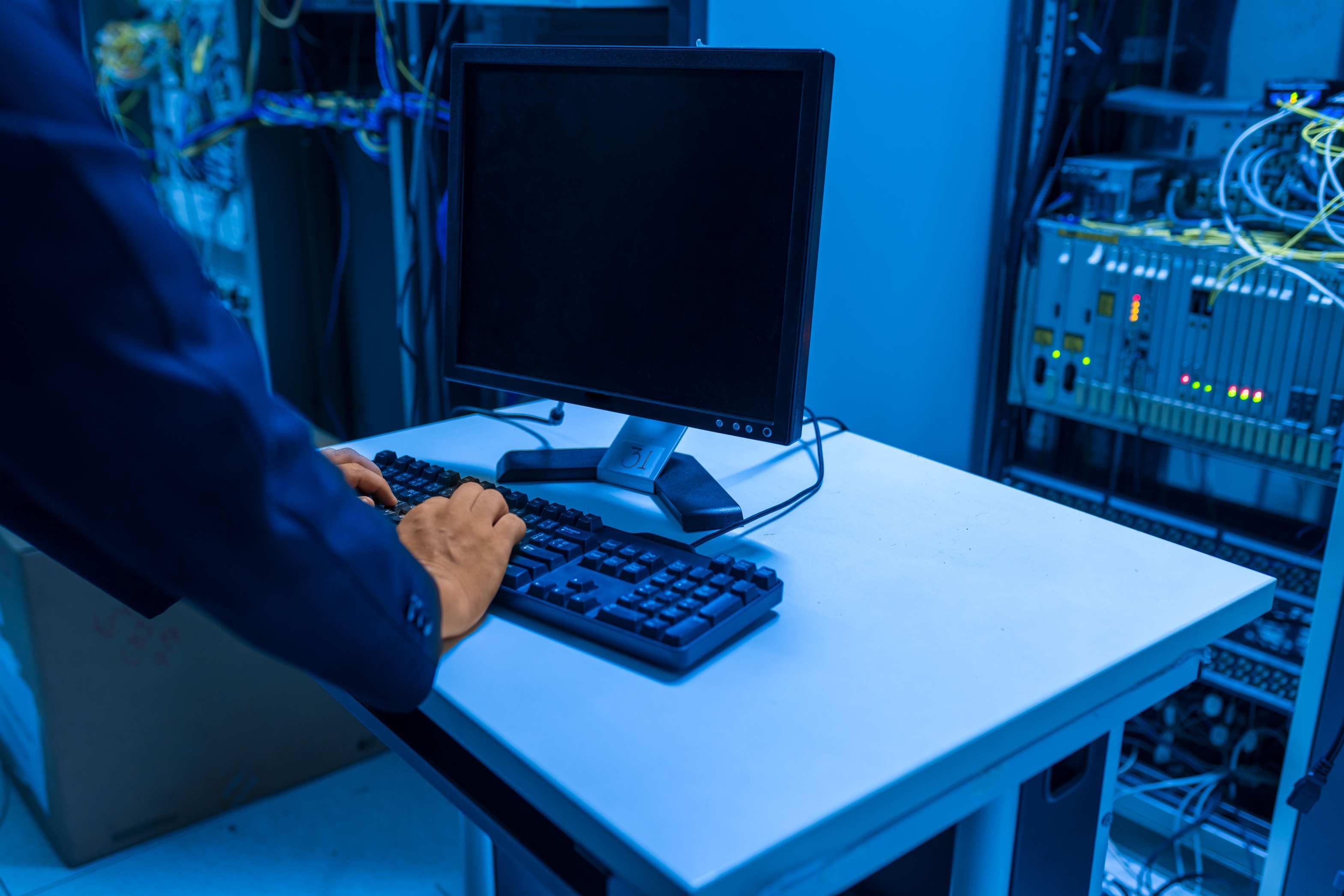 Illuminated server room aisle at night with network systems